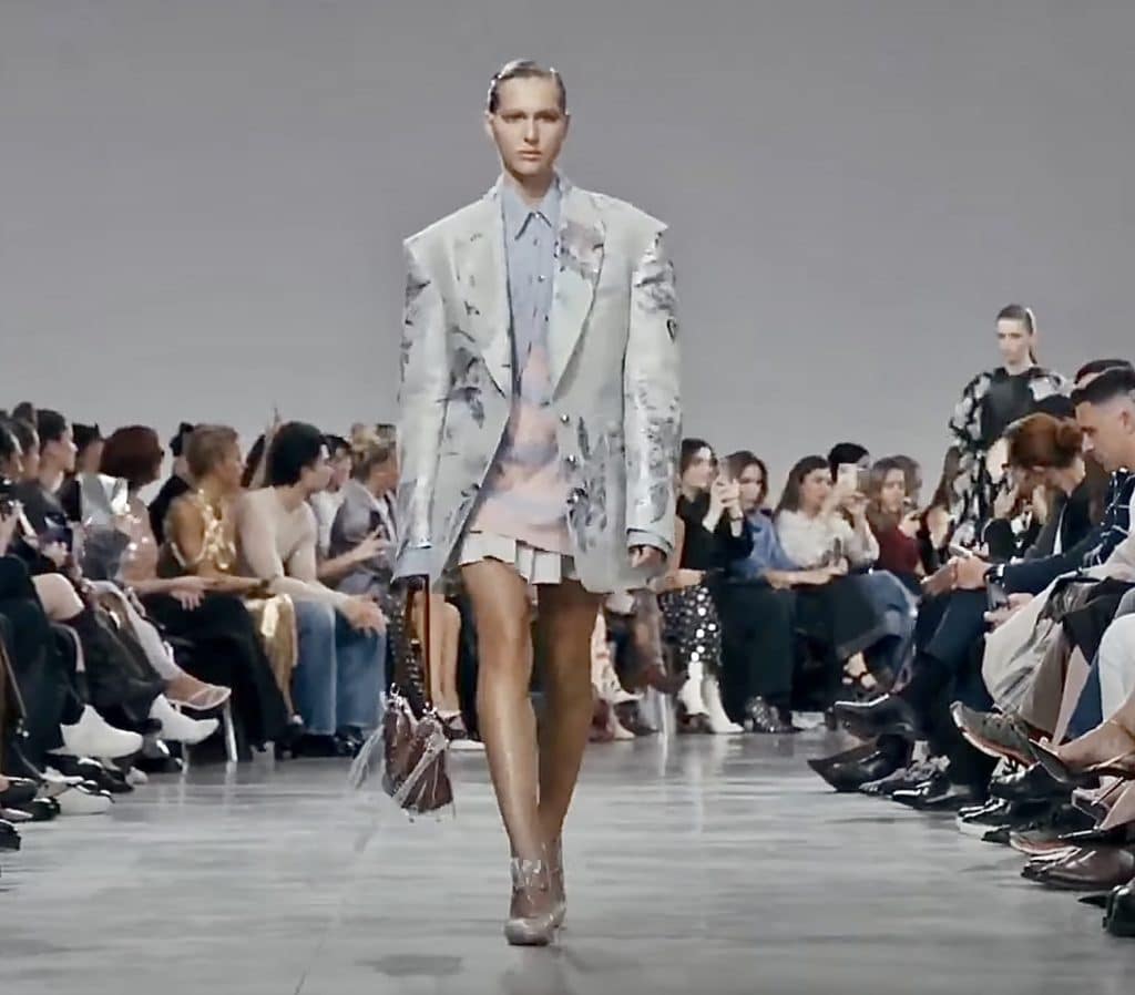 model at Paris fashion week 2024 wearing a silver shoulder pad blazer with a gray and pink outfit